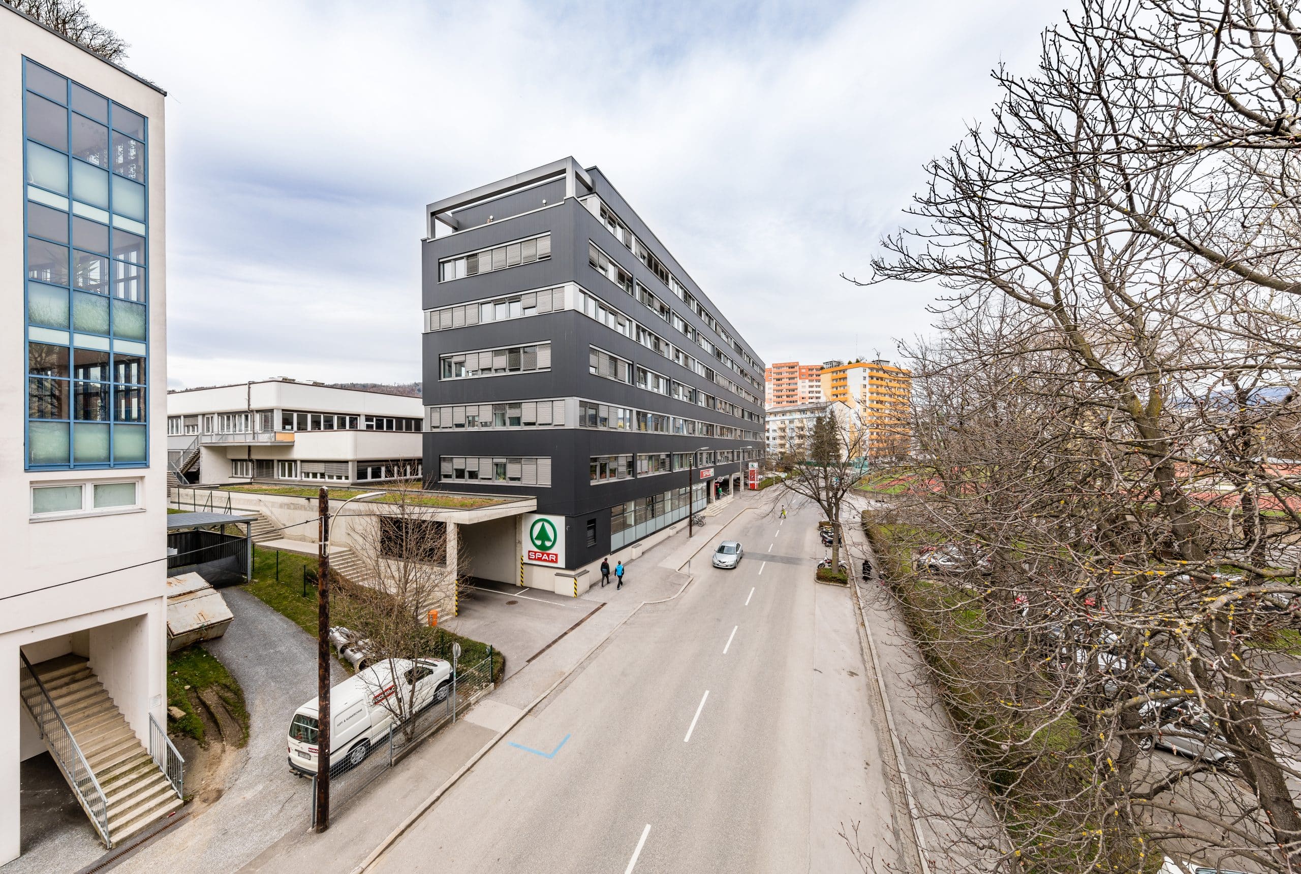 Mehrstöckiges Bürogebäude an der Mariengasse 63, moderne Fassade, Stadtstraße mit geparkten Autos.