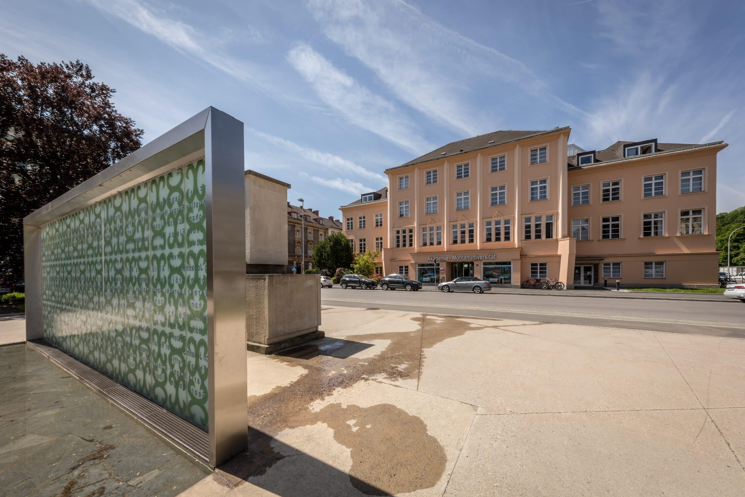 Historisches Gebäude der Montanuniversität Leoben mit moderner Glaswand im Vordergrund.